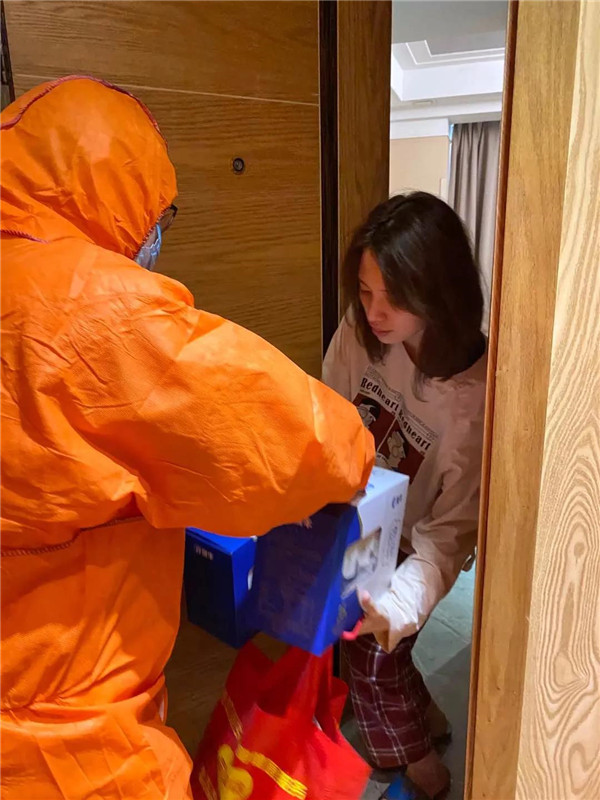 通过驻点工作人员向返乡侨胞送上爱心包等慰问品.jpg