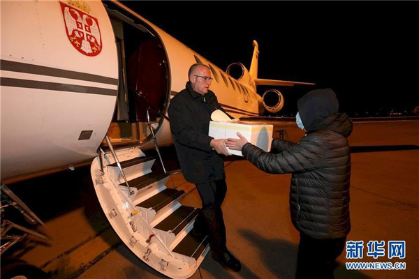 3月15日，在塞尔维亚首都贝尔格莱德机场，工作人员搬运装载着新冠病毒检测试剂盒的箱子.jpg