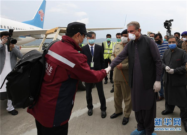 3月28日，在巴基斯坦伊斯兰堡国际机场，巴基斯坦外长库雷希（前右）与刚刚抵达的中国政府赴巴基斯坦抗疫医疗专家组成员握手。.jpg