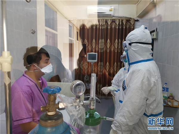 4月4日，在老挝首都万象150医院，中国抗疫医疗专家组成员（右）探访老挝新冠肺炎患者.jpg