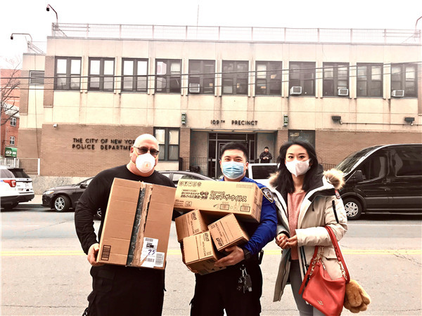 旅美侨胞王早早（右一）代表其运营的华文学习中心学生和家长，为纽约警员送去捐赠的医用口罩.jpg
