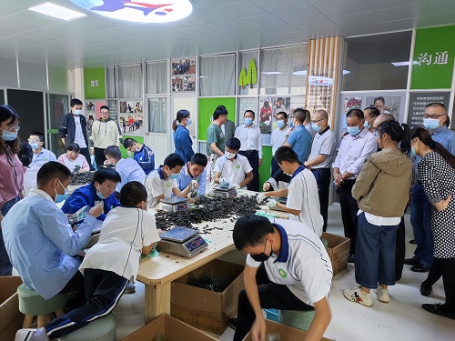 活动人员一行参观电商产业园特殊儿童做工现场照片.jpg