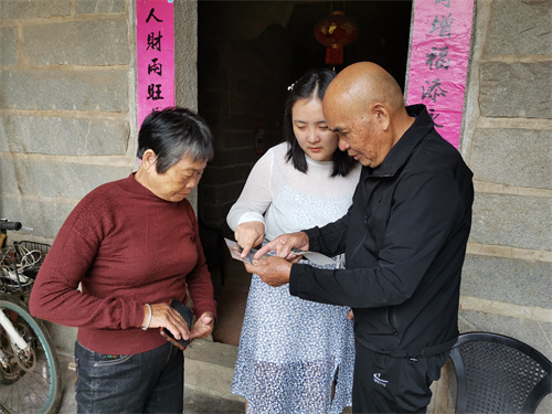 惠安县侨联工作人员查看陈永福一家保存的旧照片并发给陈兴麟确认  黄雅青摄.jpg