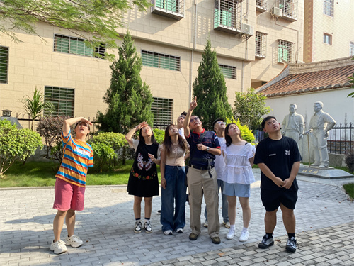 魏达人在陈列馆前给华侨大学生们讲解。黄桂荧 摄.jpg